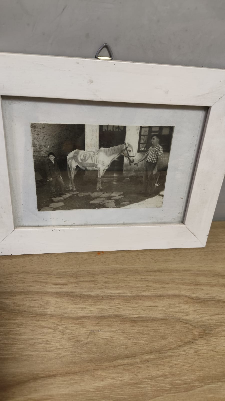 Fotografia antiga ainda posicionada em um porta-retrato branco